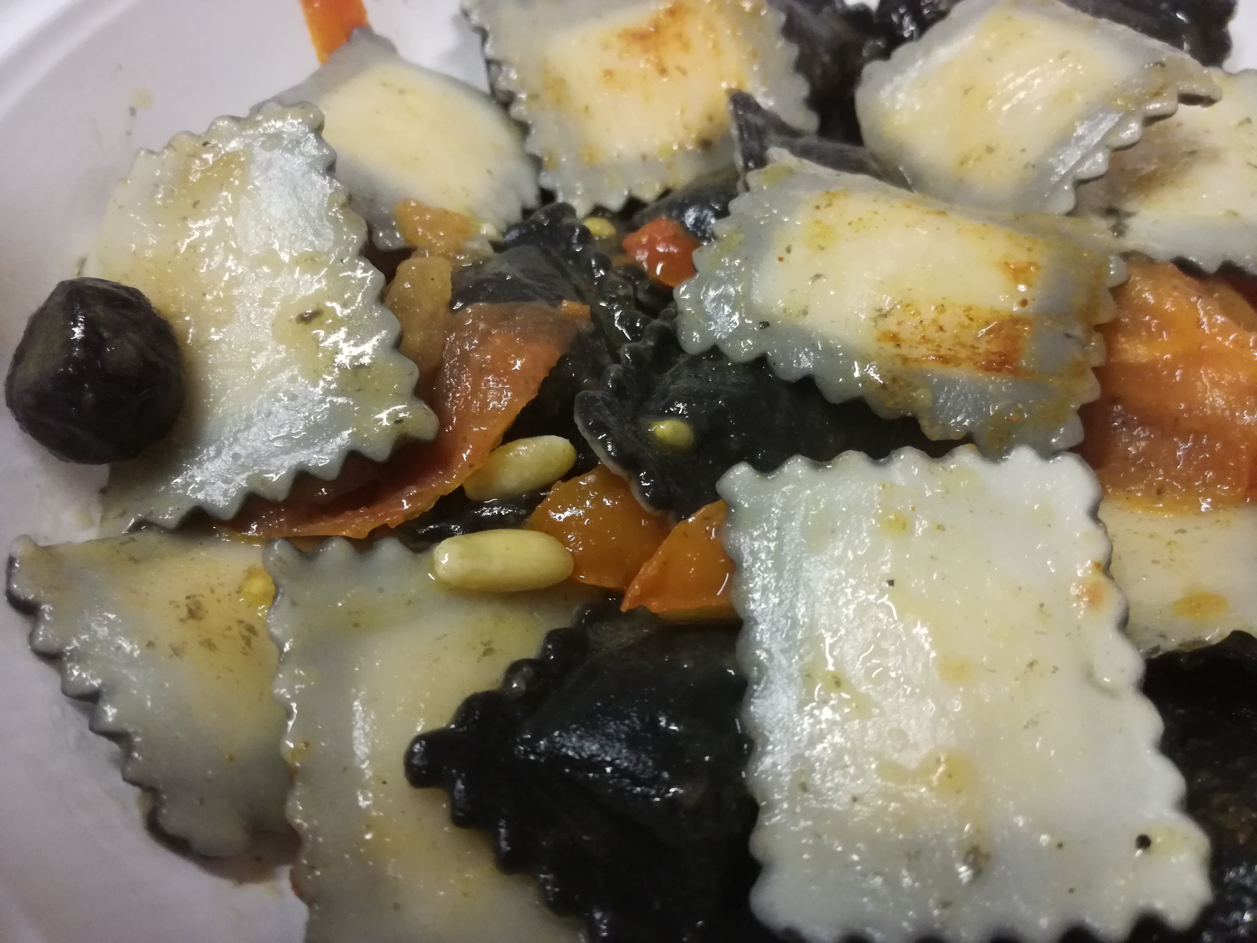 Ravioli di pesce con pomodori e olive al forno